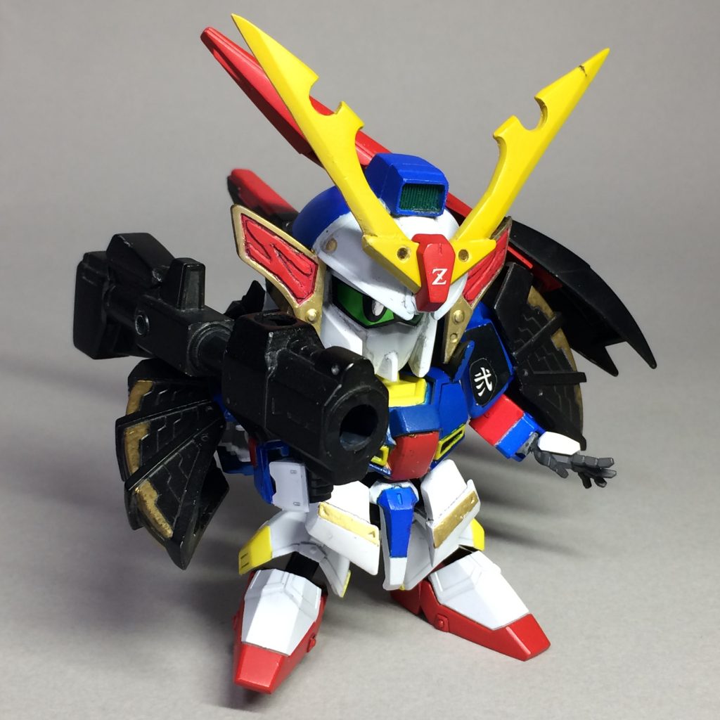 BB戦士ゼータマンのアイデンティティでもあった巨大なバズーカは、『HGBC 1/144 紅ウェポン』付属のバズーカの先端にムシャカゲゼータ(ゼータマン)のバズーカの先端を移植し、旧HGUCゼータガンダムのライフルのエネルギーパックを後部に接着して製作しました。
銃身は伸縮し、使用しないときはリアビュー写真のように肩鎧にマウントさせることができます。