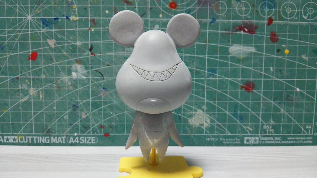 パテで作った耳を同じくパテ盛りした頭部に接着。口をスジ彫りしていきます。