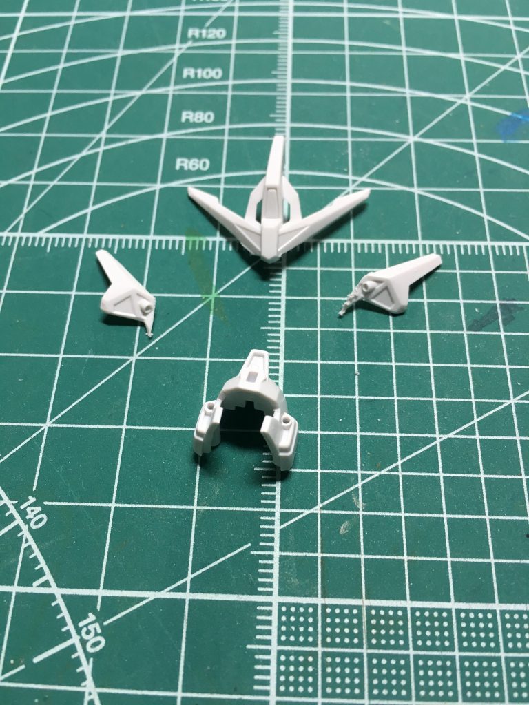 頬あてと襟足は大胆に切り、首を動かしやすくしました。首が回るようになれば、ポージングにも幅が出ます。ひさしは削り込み、ツインアイが見えやすく加工しました。より精悍な表情に出来たと思います。
 ホビージャパン2014年5月号付録の「カレトヴルッフ炎」から、ハイパーZガンダム炎用ヘッドギアを流用。そのままではツインアイが隠れるため、アンテナ下部を加工しましたが、前髪ぱっつんみたいな姿に…左右のバルカンユニットは隙間が空くため切り離しました。切り離したサイドのバルカンはメガビームライフルに接着。