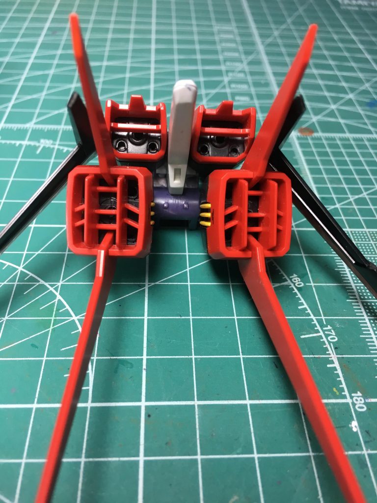 エールストライカーはウイング可動部のある上部パーツと、フィンがついた下部パーツに合わせ目があります。上部パーツはスラスター内部のディテールアップと合わせ目処理のため、O ①番パーツの後部にあるバーニアユニットをエッチングソーで切り取り、O ②番の同一箇所にプラセメントで接着。乾燥後にバーニアを表現した丸モールドをピンバイスで開口。
下部パーツはフィンの接続部を削り落とし、角度を開き気味にして後ハメ化。こちらも左右ブロックの貼り合わせなので、接着、乾燥後にピンバイスでバーニアのモールドを開口。
下部パーツのフィンの後ハメ加工はマルチプルアサルトも共通です。