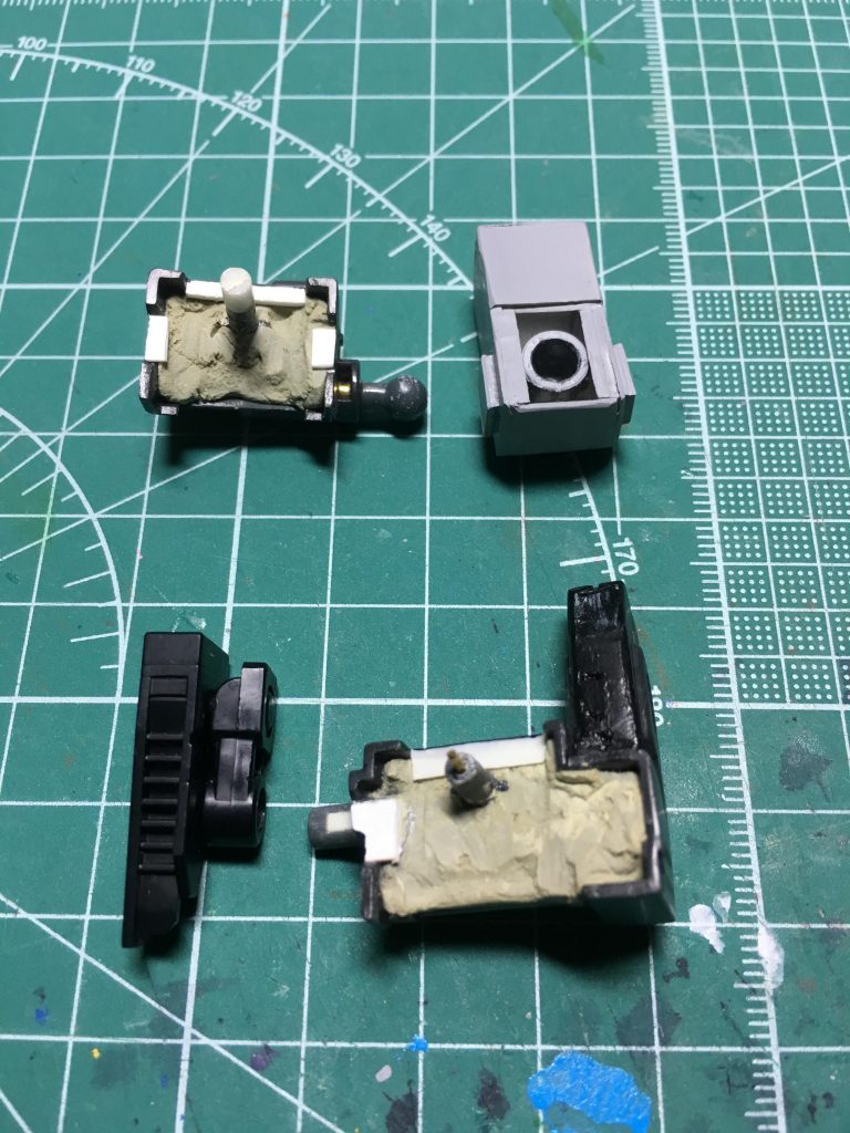 ソード・ランチャーの基部はBB戦士のスカイグラスパーとのセットから流用。裏側をエポキシパテで埋め、背中との隙間を0.3mmプラ板で埋めます。
軸は0.5mmシンチュウ線を仕込みながら約2mm延長しました。
接続軸はジャンクパーツの中から見繕っています。ランチャーは股関節のボールジョイント、ソードは腰軸(5mm径)を使用。ソードの軸はそのままでは回転させるとねじ切れてしまうので、紙ヤスリで削ってクリアランスを調節。
いずれも1.5mmシンチュウ線を通しながら接着。プラセメントでがっちり固定します。ソードのマウントは塗膜との干渉を避けるため内側を削っています。