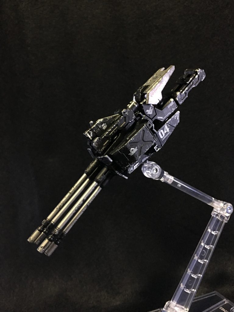 多連装機関砲「神々の弾冠」
軽量化・反動軽減のため小口径ですが、衝撃を受けると3つに分裂する特殊なHP弾を使用し威力を保っています。
根元のアームで上腕部と接続することで保持力を上げています。