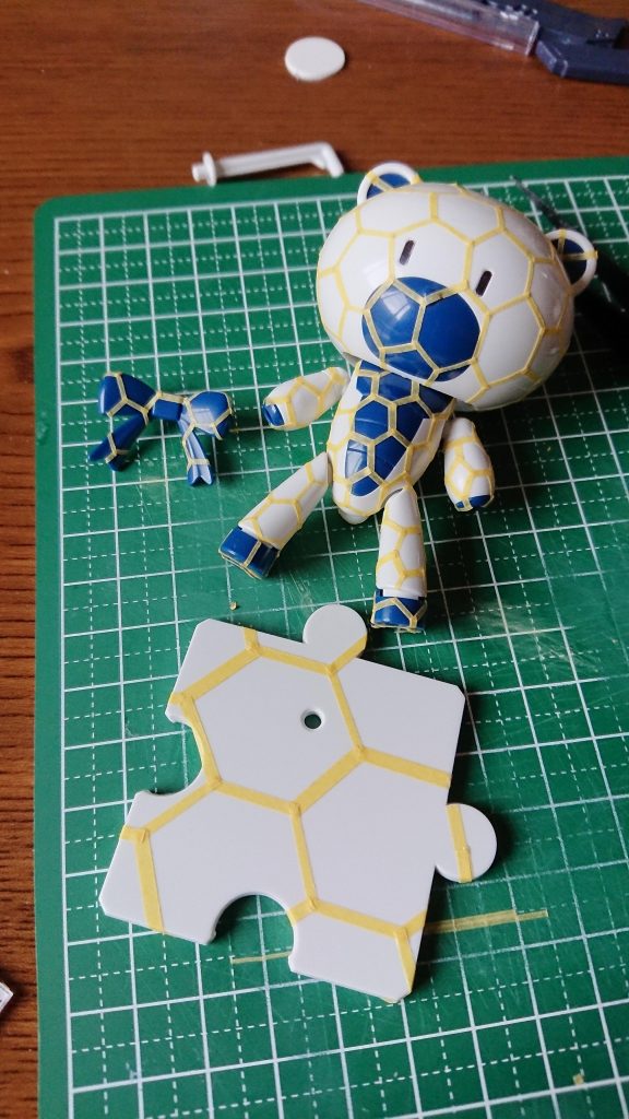 こんな感じで、ガンダムベースモデルのプラモをマスキングし、クリアに畜光粉末を溶かしてエアブラシで吹いてます。