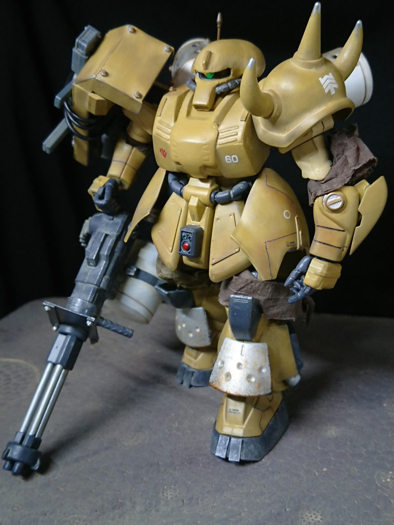 〜設定〜
本機は公国軍が一年戦争末期に試作したモビルスーツであり、ゲルググとは別に次期主力量産機を模索する形でザクⅡ改をベースに開発される。肥大化した胴体に収められた高出力ジェネレータによりビーム兵器のドライブが可能。しかし、機体の高機動化を目的に実弾系の武装を多用する。
そのコンセプトは「ザク、グフ、ドム、ゲルググ」どの機体とも同時運用が可能な機体として少数試作され、格闘能力の高さやホバー走行などにコンセプトの反映が伺える。
またこの機体はジオン残党の手によって改修されており、便宜上「陸戦型」と呼称され、残党の活動域のアフリカ近辺にあわせて全身に防塵処理が施されている。
装備は専用ガトリング、マシンガン、シュツルムファウスト、ビームサーベル、シールドナックル。