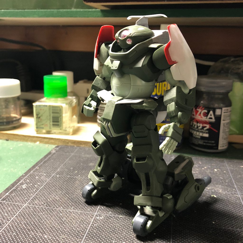 こちらは塗装前の状態。まだショルダーアーマーの形状が決まっていない時の写真です。
ウィング等はプラ板工作、流用パーツはビルドダイバーズ関連とジャンクの山から発掘された出土品でまかなっています。ショルダーアーマーに付けたのは……たぶんGNアーチャーのモモのあたり……かなあ。
この時点ではショルダーアーマーが上腕カバーを兼ねていますが、最終的にはサイドアーマーと同様に横向きにセットして、サブスラスターユニットとしました。上腕には別途製作したカバーをつけています。肘関節が挟み込みなので、つなぎ目をカバーで隠している形ですね。
足の可動に邪魔なフロントアーマーは撤去し、ウィングに変更。ふんどし部分はフィン状に加工。
穴をあけたりウィングをつけたり、ミニ四駆みたいな改造してますね。