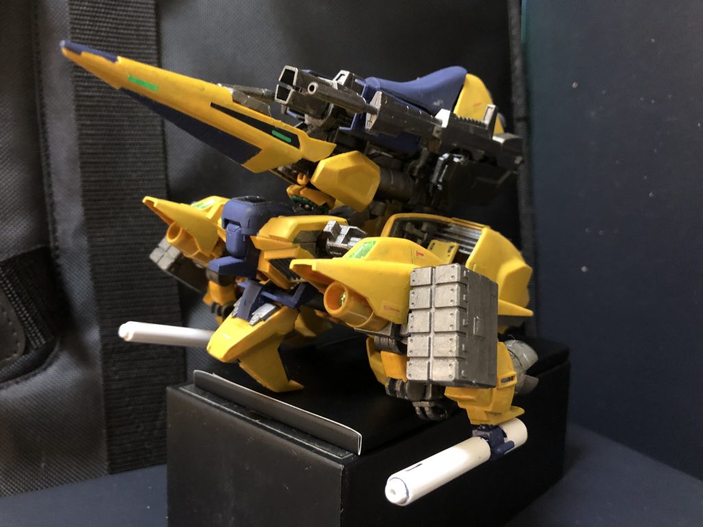 ③ 可変方式の変更
以上の改造を行った結果、本来の可変方式では可変出来なくなってしまったので、可変方式を変更した。大筋では変わらないが、腕、脚の可変方法が変わっている。
④ ウェポンラック
背面ユニット両側にロングビームライフルを2挺設置できる。リックディアスを彷彿させるが、この装備は実は本機が使用する為ではなく、僚機の武器がエネルギー切れを起こした場合の予備である。また、ビームサーベルも脚部内に片側で3本、計6本装備するが、こちらも僚機の予備武装として使用される。