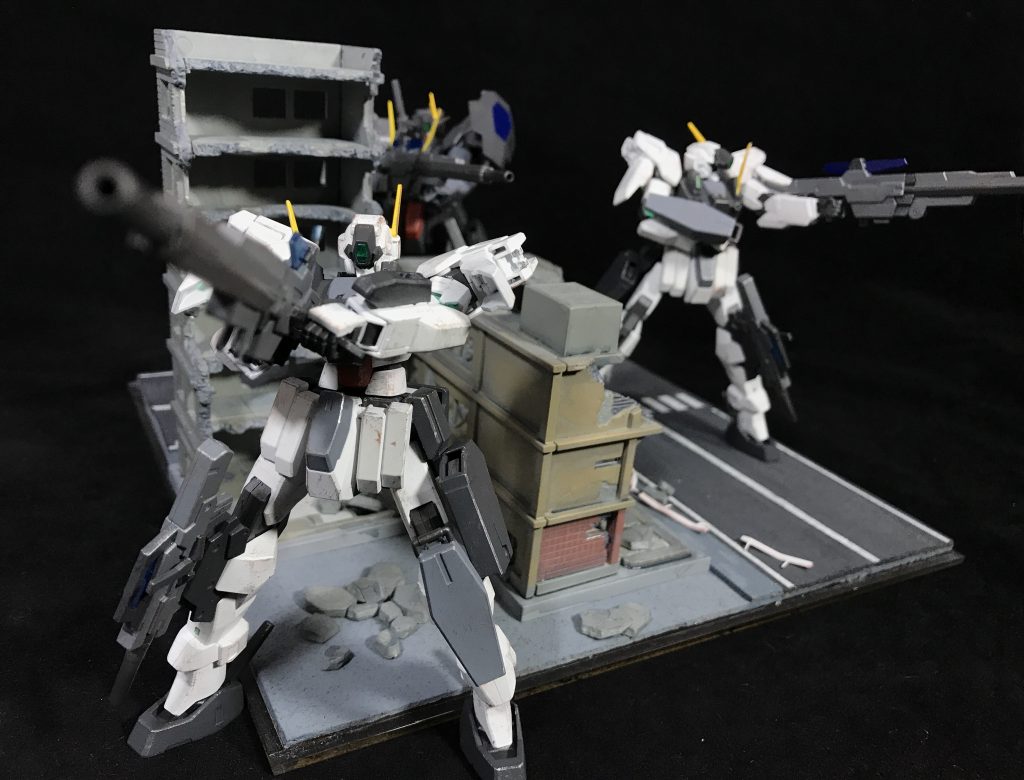 ## [スロウンズ・システム]
ヴェーダへのアクセスが不可能な状況や別の戦域でトライアルシステムが稼動中の状況など、何らかの理由でトライアルシステムが使用できない状況下において運用可能な無人兵器として開発された兵器群および運用システムの総称。

大型クラビカルアンテナを用いて各機がヴェーダを介さずにデータリンクを行うことで高度な連携を行うことができる。
基本的な編成は指揮官となる有人のMS1機に2機の無人機が随伴するというもので、ガンダムマイスター1人で擬似的な小隊の運用を可能としている。

また、同系統機体3機による連携というコンセプトはソレスタルビーイング、チームトリニティのスローネシリーズと共通しており、システム名および機体名称としてスローネの複数形であるスロウンズが採用されている。