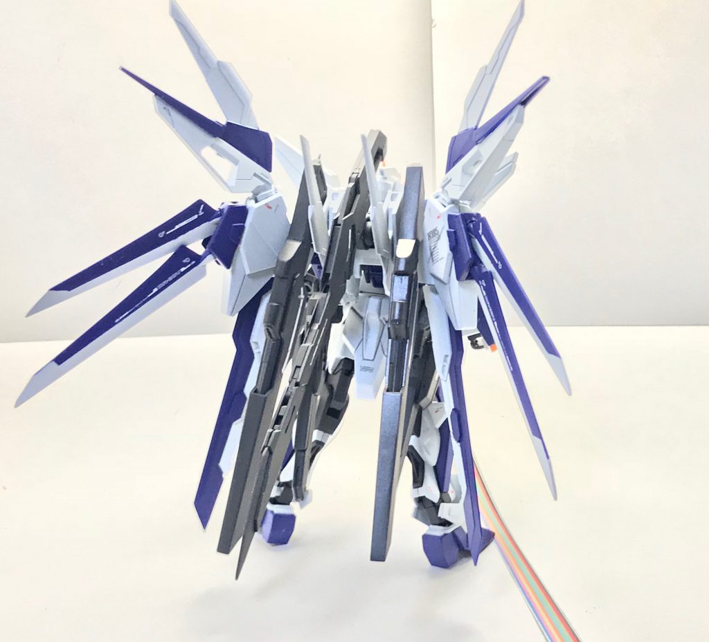 背面。アブソリュートストライカーの大型ウィングは空力を得るというよりもDSSDから不完全な形でしか入手できなかったデータやヘブンズベース及び月面ダイダロス基地で目撃されたデスティニーガンダムとの戦闘データを元に継ぎ接ぎで作られたヴォアチュール・リュミエール(の近縁種)を無理やり制御するためのスタビライザーとしての意味合いが強い……という設定。真ん中にある大小それぞれ2基の翼は余剰出力を活用するために設置されたブレードドラグーンであり、ストライクフリーダムガンダムのインスパイアである……という設定。