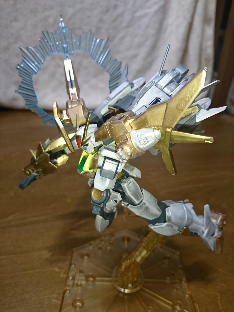 「リク!」「リク君!」
それは間違いなくリクのダブルオースカイだ。だが、その纏う輝きは通常のトランザムの赤でも、通常のソレを越えて至った青でもなかった。青い装甲は金色に、白い装甲は白銀に染まり、眩しいほどの輝きを放っている。それはまるでタイガーウルフとシャフリアールの象徴的な色をその身に纏っているようだ。
そして驚愕に目を見開いたのは二人だけではない。
「そんな、バカなっ!?」
誰よりも驚いていたのはキョウヤだった。
自らが放った必殺のEXカリバーをリクのダブルオースカイは正面から受け止めてみせた。いや、それだけではない。なんとEXカリバーの黄金の光を遡るように突き進んで来るのだ。
よく見ればダブルオースカイは超高密度のGNフィールドを纏い、それによりEXカリバーを無効化している。だが、何故そこまでの出力が出るのかがキョウヤには理解出来なかった。
だがその答えをリクは直感的に理解していた。