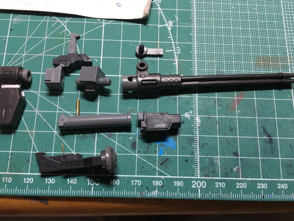 本来背面に装備しているメガガトリングガンは手持ち武装に変更。マガジン、銃身、棒状パーツに分割。銃身は後部の給弾ベルト取付部分をさらに切り離しています。
 システムウェポン005の組み替えパーツを使用し、レドーム、増加のEパック、グリップを足しました。ウェーブのプラサポも併用し、手持ち銃身を延長して大型化しています。一部パーツはシンチュウ線で接続し、塗装後に接着しています。フォアグリップは元からあった可動軸を活かしています。