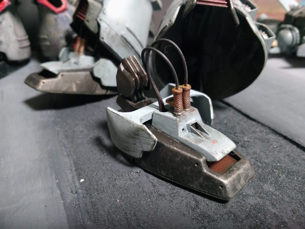 足首部はHGダナジンの脚部の関節パーツを利用してHGUCザクの足首の要領で大きく可動できるように
しました。
本来の足首固定ポリキャップを保持していた柱の位置に球ポリキャップを固定しています
先端のコードは電飾改造をしようとしていた名残、
兼目隠しディテール。
本来の足首の位置よりかなり後ろで動くことになるので、その違和感を消すための壁です。