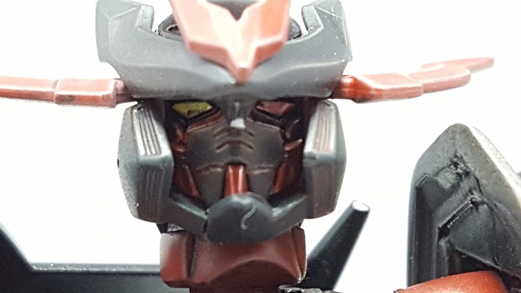 マスク部にはひび割れのようなものがあるが、ガンプラを喰らう際にここが開口される。
それまで一切の通信に応えない彼だが、喰う直前にこう通信が入るという。
*1000ひく7ひく7ひく7ひく7はあああ？*