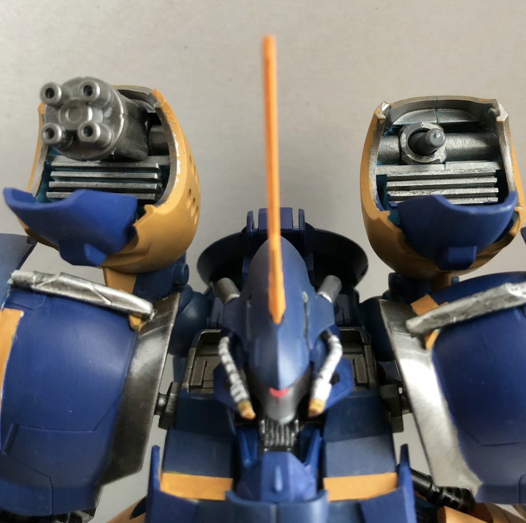 背面バックパックに装着されているサブアーム。
   左サイドは四門ガトリング砲、右サイドは3ミリ軸の自由枠となっていて戦況に応じて敵機のパーツを取り付けることも可能となっている。
   使わない時は、推進力強化のバーニアとして機能する。