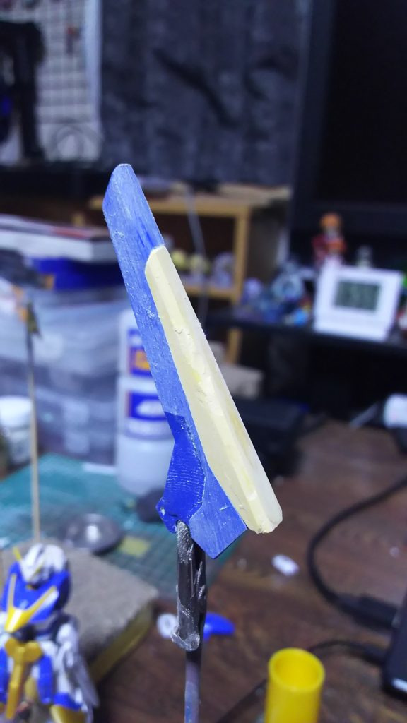 羽の黄色いパーツにパテを盛って青いパーツとの段差を無くしている様子です。
この作品で一番苦行だった部分です。
段差を無くしたのは上にも書いたように小さく見えるからというのもあるのですが、実際はガンダムのゲーム(動物園)のデザインが見慣れているから不自然に見えたというのが1番の理由です。