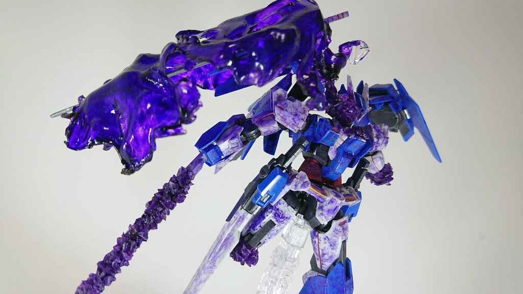 ビームマント<バグ>
右肩のGNドライブから<バグ>を噴射し、マントのような形にしたもの。
結晶化はしていないものの、ビームを通さない程のものである。