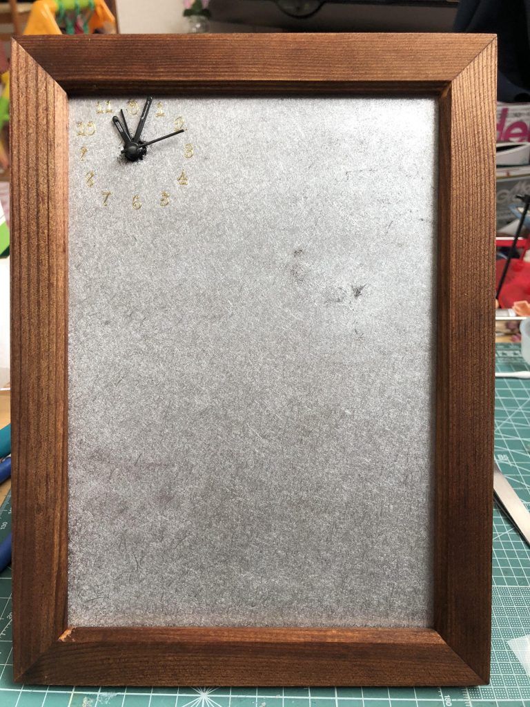 写真立てのボードをそのまま使用しています。それから100均の置時計を分解して取り付けています。この背景選びも悩んだのですが、コルクボード?の様な荒い感じの質感にガイアノーツさんのプレミアムミラークロームを吹き付けました。何だかいい感じになったなーと思いました。