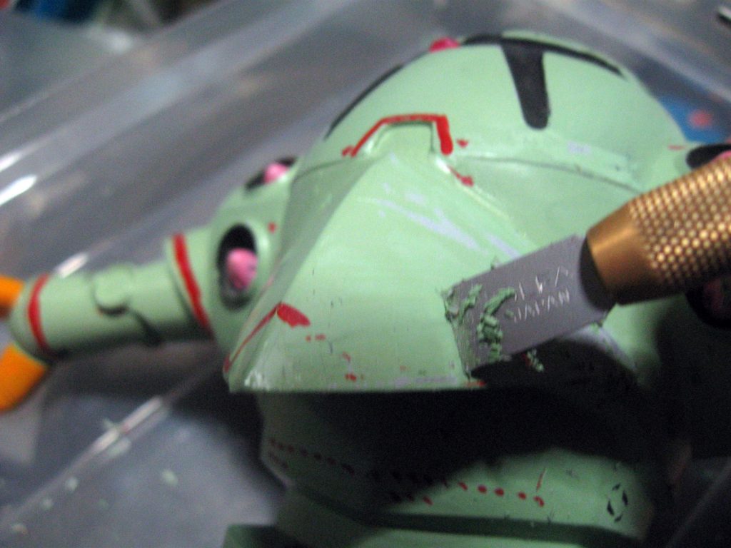 旧キットの再塗装の為に厚い塗膜をデザインナイフで削り取ります。