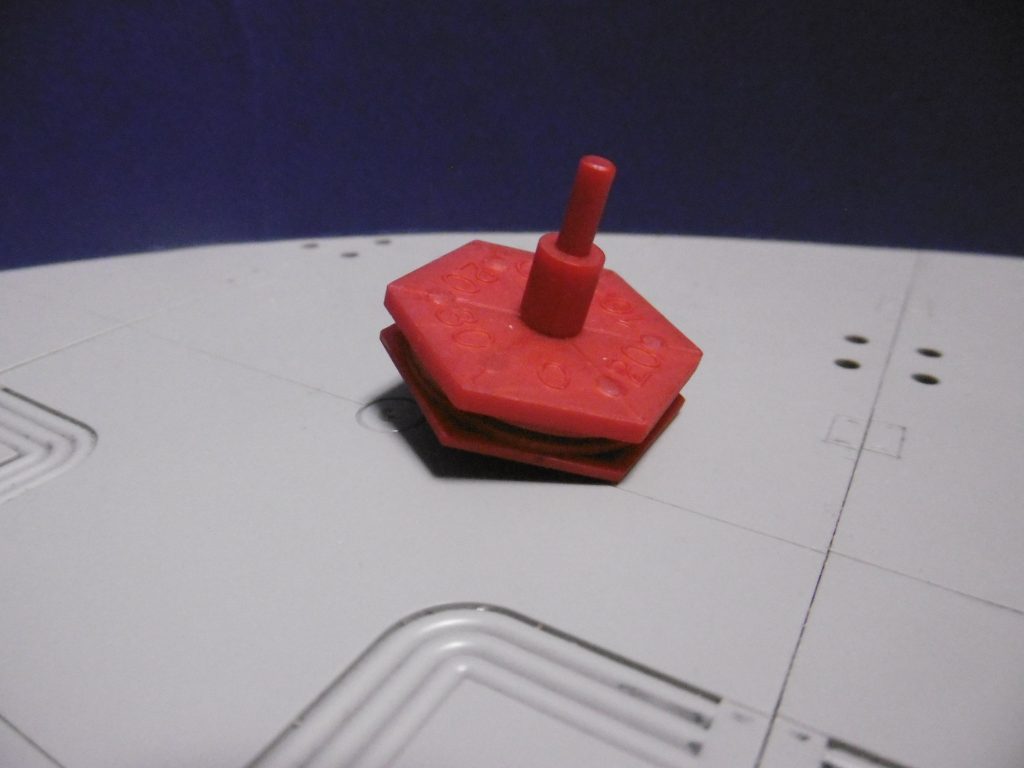 放下師であれば、大道芸と称して特殊な忍具も手品の道具と見做され、怪しまれずに持ち込めます。ＳＤ大旋鬼頑駄無の旋風六角独楽を拝借し、改造しました。一見ただのコマなのは偽装用＆陽術用

普段は通常の独楽として、芸にも使います。人目を引きつけたり陽術にも使える目的で赤色（成型色のままツヤ消し）。術を仕掛ける場合は軸側の上盤を上下逆に。