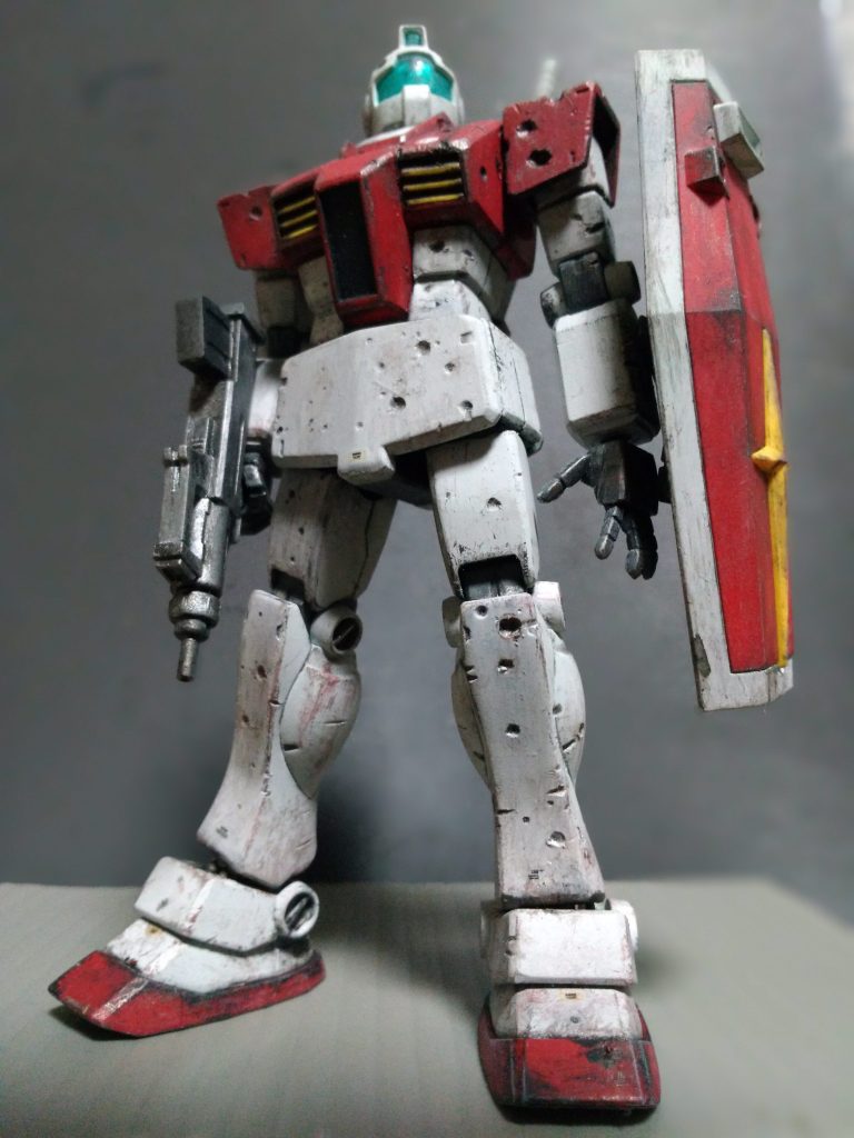 HGUCジムにダメージ加工を施しています。
120mm弾が装甲表面に着弾し、弾が炸裂した破片や擦過した弾丸によってついた傷を想定しています。
世界大戦の時代の戦車の写真などを参考に、「120mm弾が装甲にめり込んで砲弾が炸裂したが、内部までは貫通せず、装甲の表面をえぐってダメージを与えたに止まった」「装甲表面を徹甲弾が掠め、傷を付けた」感じを出しました