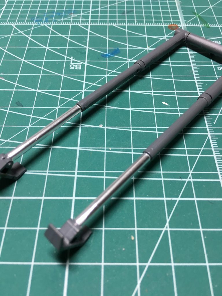 　背面に装着するジャッキは肉抜きをプラ板で埋めました。0.75mmプラ板2枚を現物あわせで切り出し、角を斜めに削り落とせば無駄なく隙間を埋められます。ホイルシールの余銀を長さ3.1mmで切り出し、巻き付けて金属感を演出。