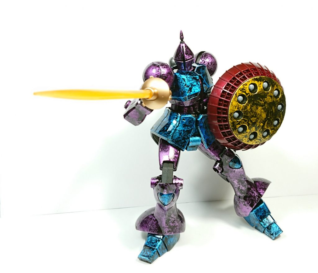 専用ビームサーベルの持ち手の部分はゴールドで、シールドの赤色の部分は下地に青鉄色を吹き付けた後に、上からクリアーレッドを吹き付けている。関節系は黒鉄色。