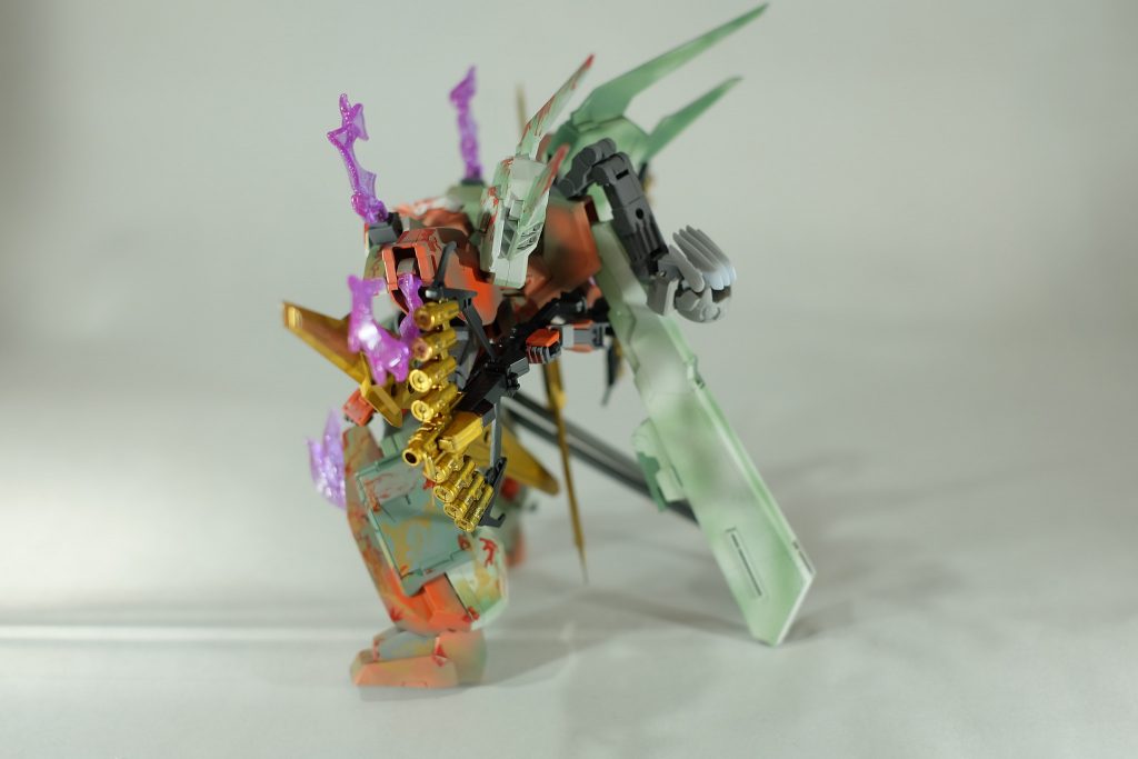 全身から吹き出す、紫に炎。
これは、機体の各所から漏れ出したGN粒子である。本来緑色のGN粒子であるが、本機の内部を通過する段階で粒子の性質が変化し変色している。