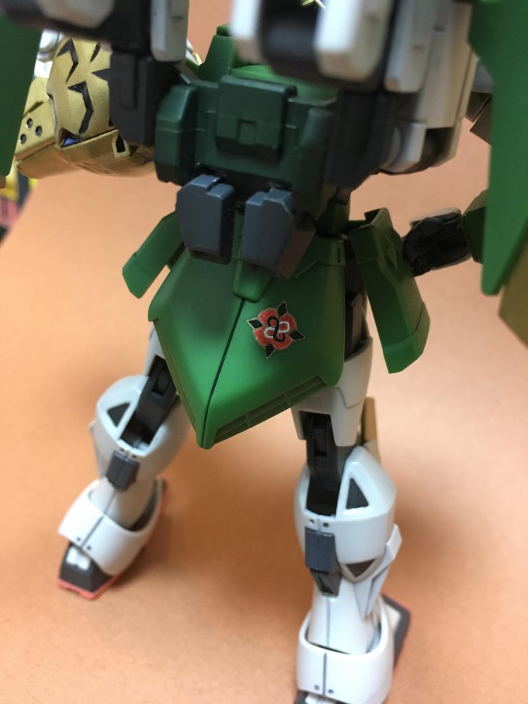 スラスターっぽい余剰パーツを加工して
追加バックパックの隙間に差し込みました。
厚みがぴったりだったので、余計な所を切り取るだけでした。
リアアーマーには虎武龍のフォースエンブレム(のはず!)を
描いてみました。下書きが完全に適当なので、そうしたなりの出来ですね。
