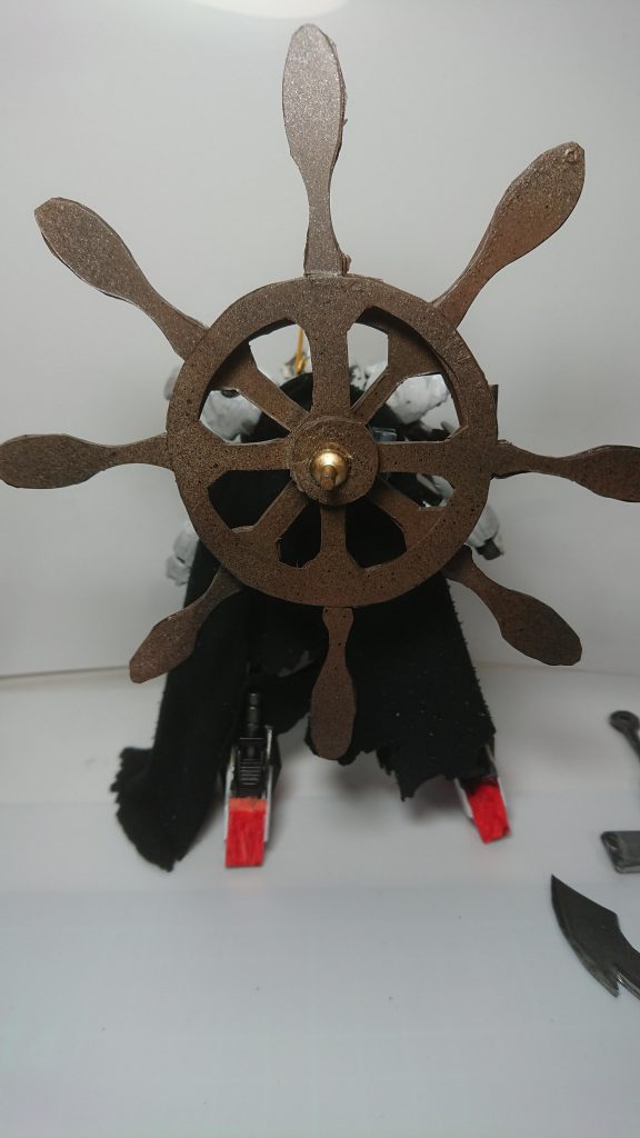 背中には舵輪を模した武装。独立して回転します。ときどきX字になるのが拘りポイント。
カラーリングが白メインなのはX-1をモデルにしているのと、鉄血の世界の塗料は白は目立つため一番安価と聞いたため。
マントは白い体や装備している武装を隠すためです。