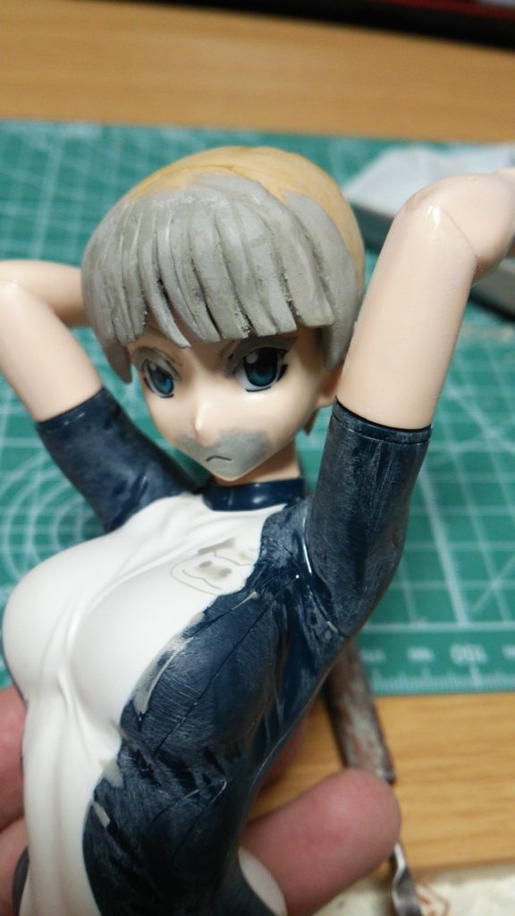 パテで髪の毛と口元、目元を部分整形。服のシワも不要部分を削っていきます。