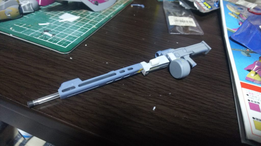 ジャンクの中にあった何かのビームライフルをバラしてくっつけて全体的なシルエットを長くました。
その他にバレルの中をくり抜いて、プラ棒を入れることで別パーツ化しました。
また、延長によって干渉するパーツの形状変更等も行いました。