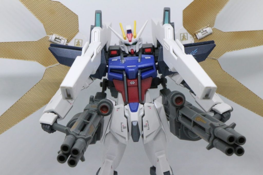 メイン兵装であるメギドストライカーパック。
肩にセットされているのが超高出力長射程キャノン「プロメーテウス」
背面のリフレクターで太陽光をエネルギーに転換してようやく使えるというトンデモ兵器。
腰にある対艦ガトリング砲は無理やり乗っけただけなので基本的に使わないことを前提としている。