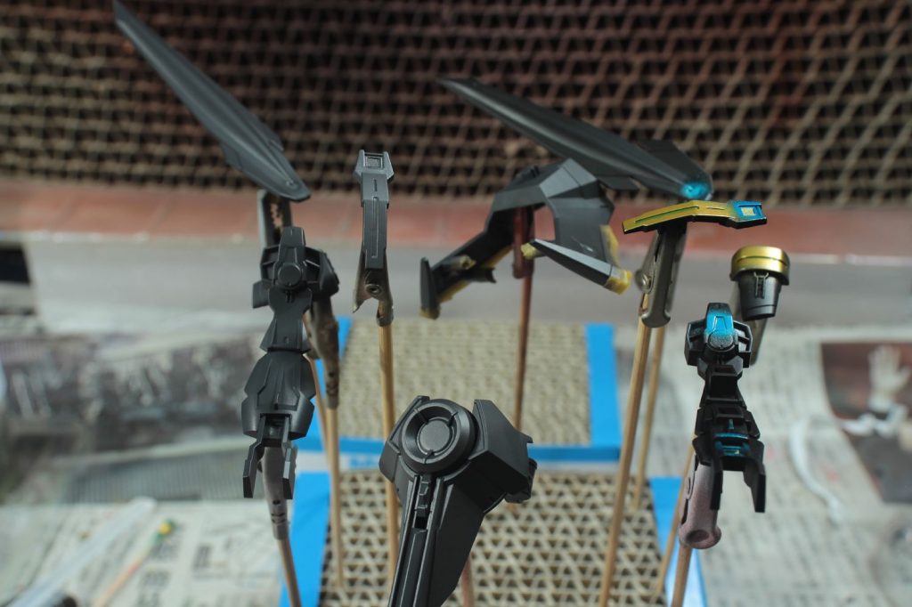 明るい色から順に塗装して行くので、白→赤→銀→金→クリアブルー→コートの流れで塗装。
赤と白はほとんどベタ塗りで対応できたのですが、ふくらはぎ上部のフレームっぽい部分だけは『マスキングリキッド』+『マスキングテープ』で対処
黒サフは済んでいたので、
ゴールド部はそのままゴールドを吹き付けで『マスキングゾル改』を塗布。
メタブルー部はミラークローム→クリアブルー→蛍光クリアを吹き付け『円形マスキングテープ』+『マスキングゾルNEO』で対処
その後に本体用の黒を上塗りしていきました。