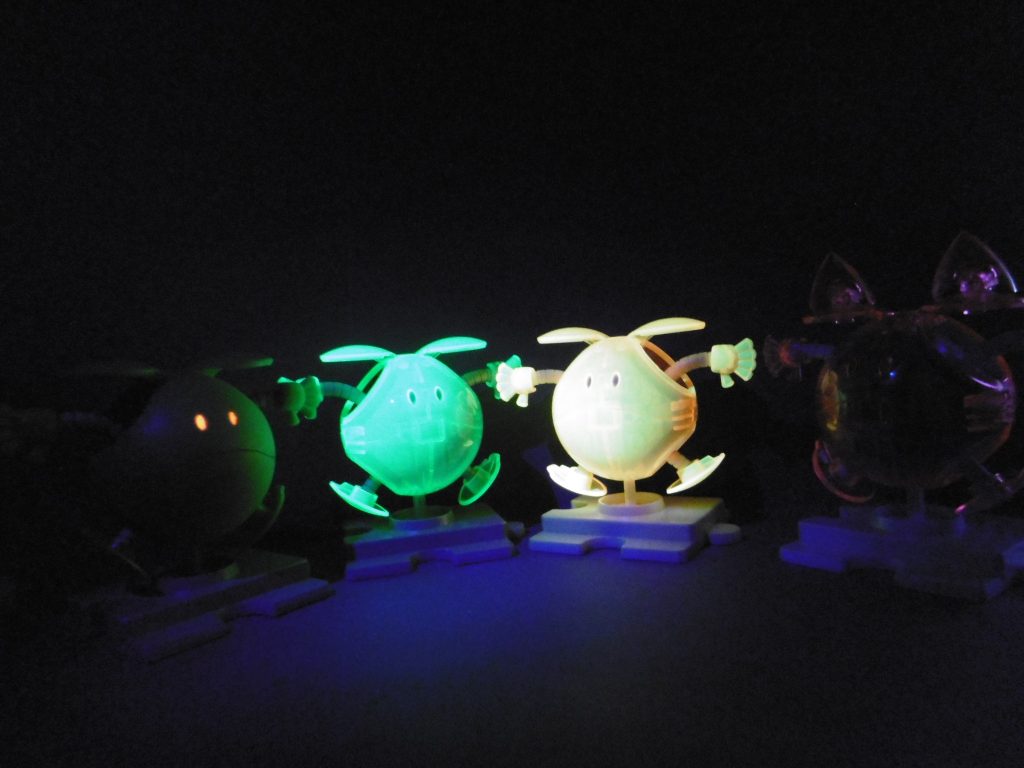 モモハロはブラックライトの光に反応し難いようで、並べて撮る場合は少し工夫が必要かも。ノーマルハロは塗装しない限り反応しないと思います。
クリアカラーのガンプラは不人気な傾向ありますが、個人的には大好き。

ブラックライトをお持ちの方には全てお勧めです。
迷われた場合、内部メカを含めて楽しみたいならモモハロも良いですね。無色クリアーのような透過性の高さで、内部のディテールまでしっかりと見えます。安価なのでお土産や来場記念にも最適。

ただし、小さなお子さんのいる家庭では【モモハロクリアー】の取り扱いには十分ご注意下さい。ブラックライトの有無に関係なく、あまりの衝撃度に泣かれる可能性有。モモハロの命を守る行動を。

赤・青・黄・棺桶も、いつか霊体化しそうですね。
特に赤と青は時期を合わせてきそうな予感。