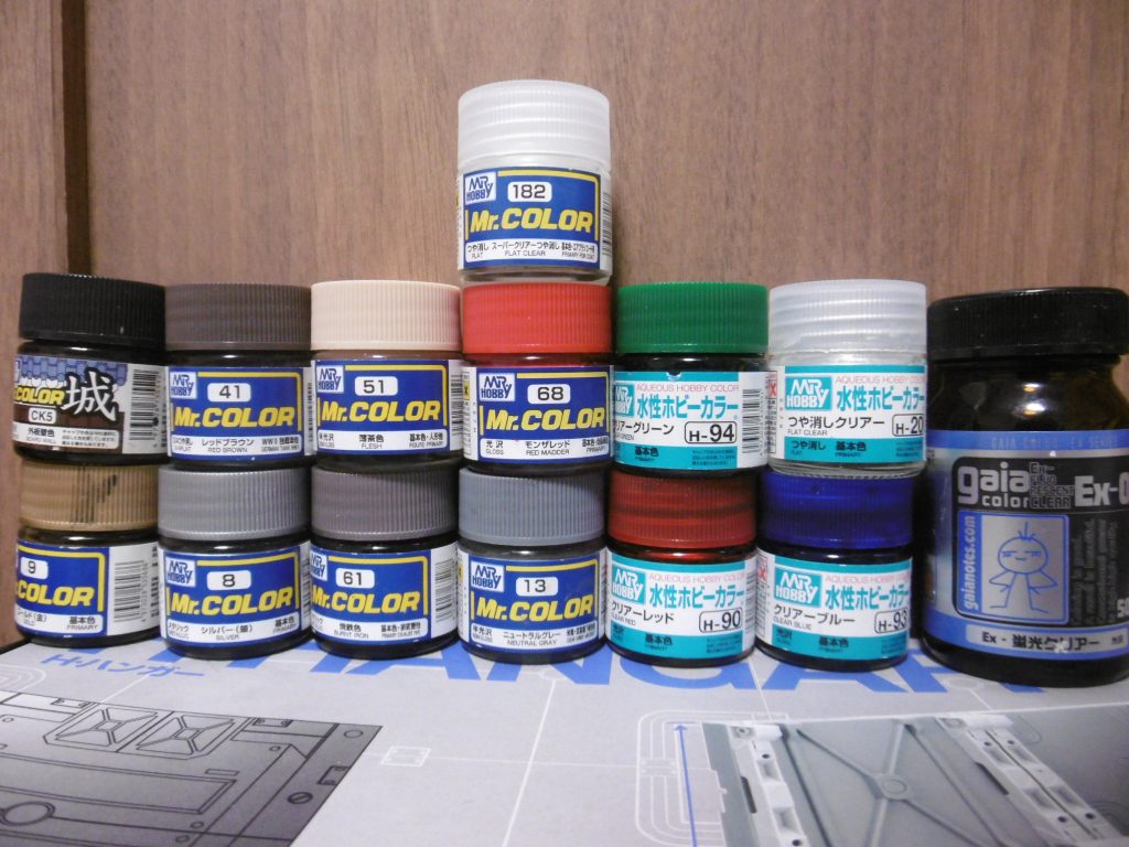 狢に使った塗料。茶色系統が中心。
城カラーの「外板壁色」は「黒に近い茶色」のようで、こげ茶より暗い？感。歴史的には茶色系の配色も正確には違うものの、本物に近い色系統ではと思われます。

つや消しクリアー２種は仕上げ用に。ラッカー性の方は成型色に直接塗り付け、水性の方はラッカー塗膜の上から。水性のカラークリアーとＥＸ蛍光クリアーは獅電バイザーに、それ以外は本体や武器などの塗装。メタリックカラーの焼鉄色のみつや消しに。