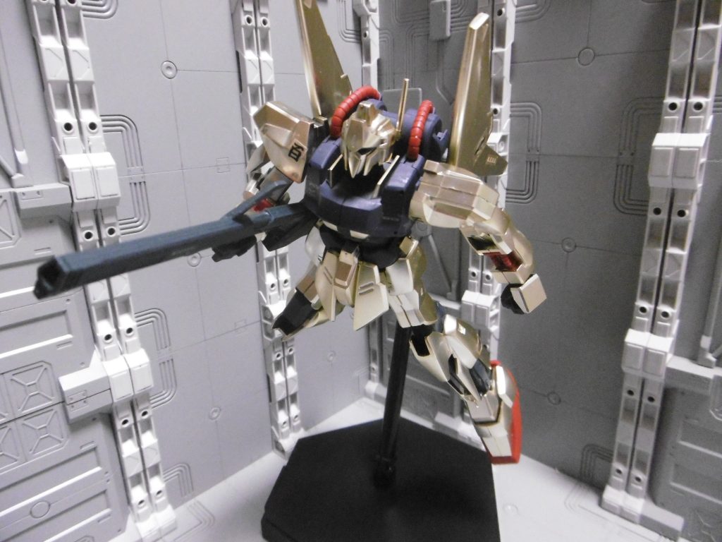 百式の成型色は、光沢の無いつや消しの金メッキ仕様に。
元のはギラギラとして指紋が付くほどのメッキでしたが、顔や部屋が映り込まない程に落ち着いた色になり、大きく印象が変わっています。他の成型色も暗めになり、紫だった胴体は青っぽく。
今ではまず見かけない「PC-120」が使われており、そこに平手が左右分付属するものの、この百式の手首接続はBJではなく軸なので使えず。腰の可動自由度は低め)。