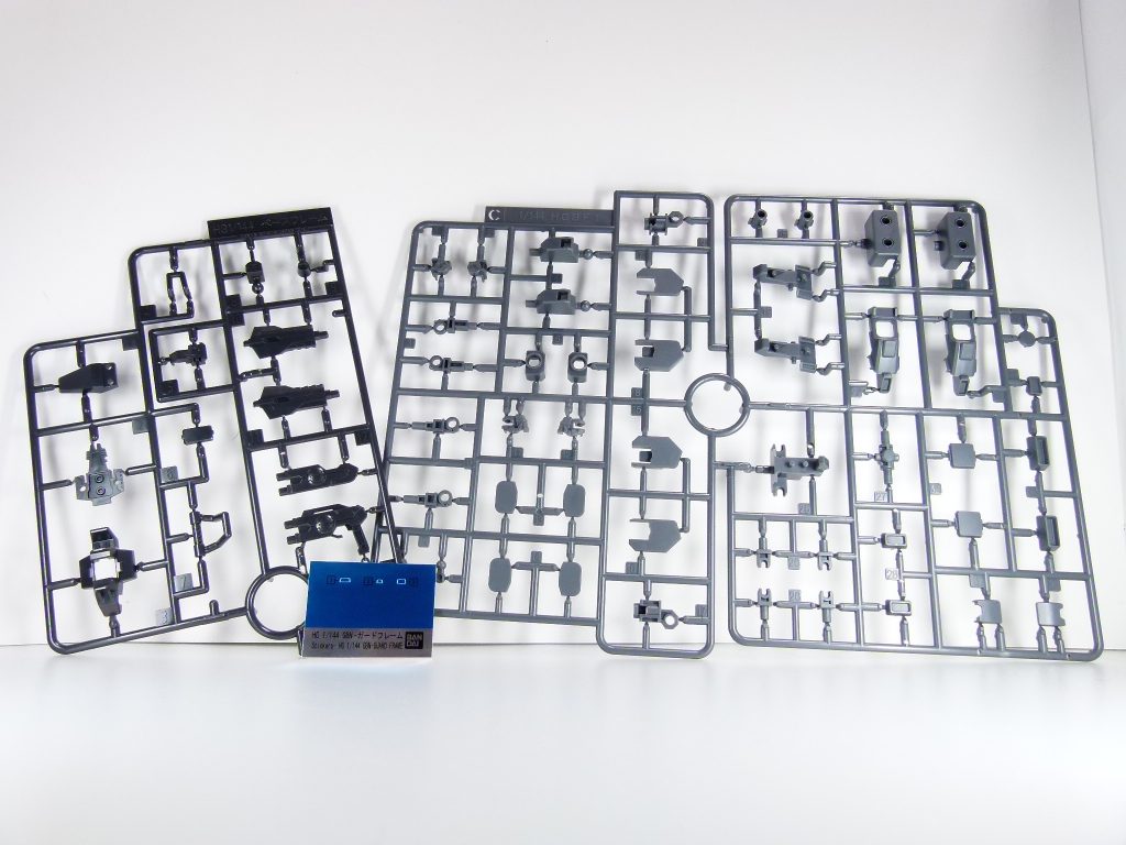 「GBNW」も実質20改。今回はついに発売された運営のガンプラ・ガードフレームの特別編です。「運営側に属する機体」としてGNネイキッドを作ったのは登場の少し前。その数話後に登場したフルフェイスの地味でいかにもカスタムできそうな機体・・・「あれ。ネイキッド?」→即発売決定の報は、ゲーマス絡みでいろいろと大変だった「ビルドダイバーズ」終盤で最大の救いとなりました。いつものGBNWの構成に則ってランナーから。本機独自の部分以外。左が「ベースフレーム」ランナー。ベースガンダムにも使うのかな。右が「HGBF1」ランナー。当初GM/GMベースって聞いていたけれど・・・あれ。これレオパルド・ダ・ヴィンチだ。ダヴィンチ用追加ランナーもちゃんと入っていてほんの一部使います。これにより、HGBD特有の「余剰」遊びができるということ・・・シールはいつもの余白(青)がありますが、今回はフルフェイス部分のシールのみ使用しています。余分は切り取ってカスタマイズに使用してみましょう。