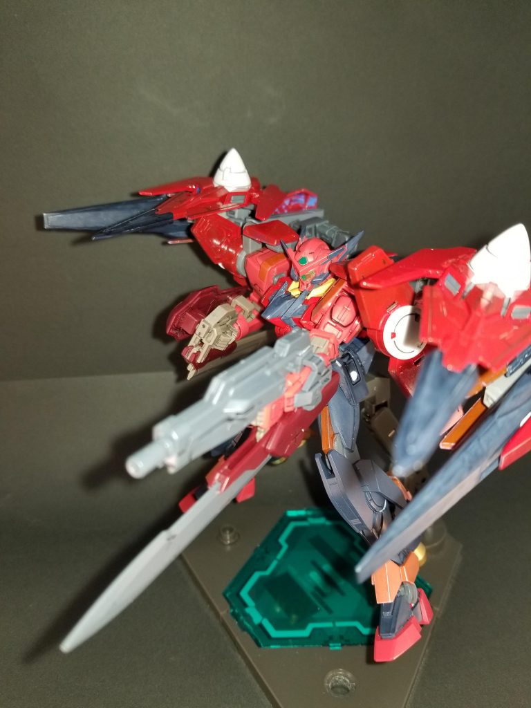 ・改善点1 射撃戦闘への弱さ 距離を離されると無力化してしまう事への対処
・改善策 射撃兵装の充実化
左腕部に固定式のGNビームライフルを装備また、新規背部ユニットとしてスーパーGNソードⅡの基部を用いることで射撃武器としても使用可能に。(ガンダムバトルオペレーションNEXT等、ゲーム作品で射撃が可能なのを確認済み)
これにより武装切り替えのロスタイムを発生させることなく、4つの射撃武装で弾幕戦闘を可能にした。