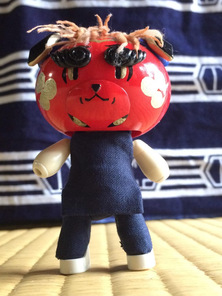 手拭いをバックに立つ凛々しい姿