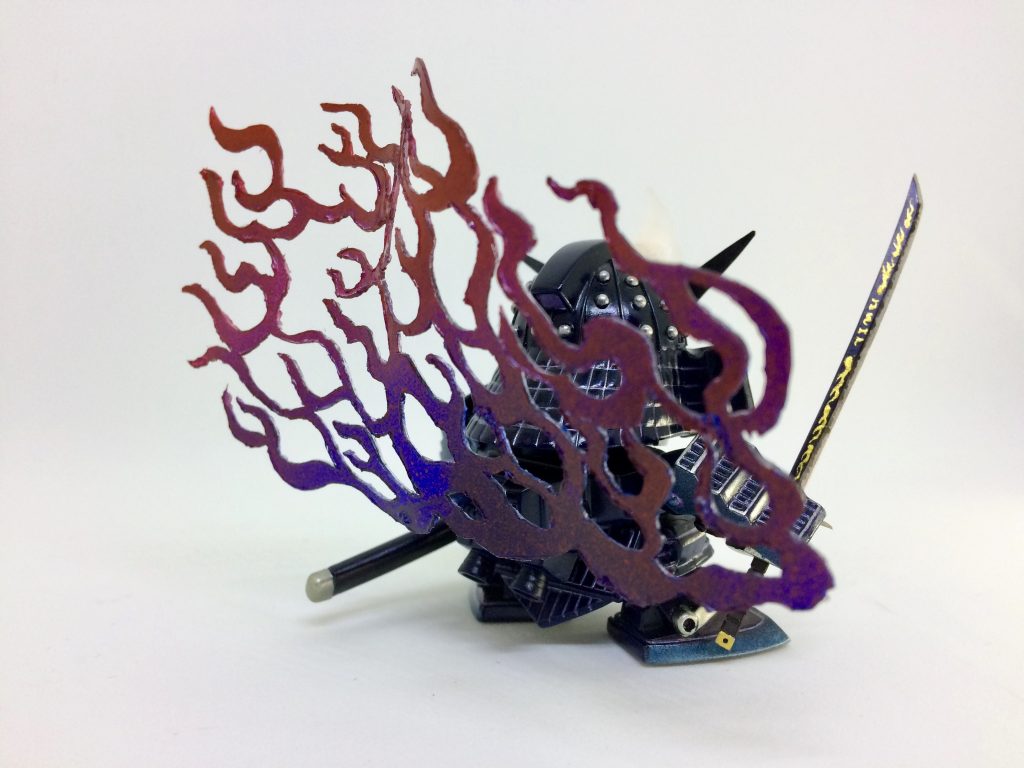 背後の炎エフェクトは炙って歪ませた透明プラ板を切り抜いて製作。ファンネル固定用の曲がるプラ棒でバックパックに接続しています。
塗装は数色の缶スプレーを重ね吹きしたりマスキングしたりして基本色を塗り、ファレホで瞳やカブトの飾り等を筆塗りしました。