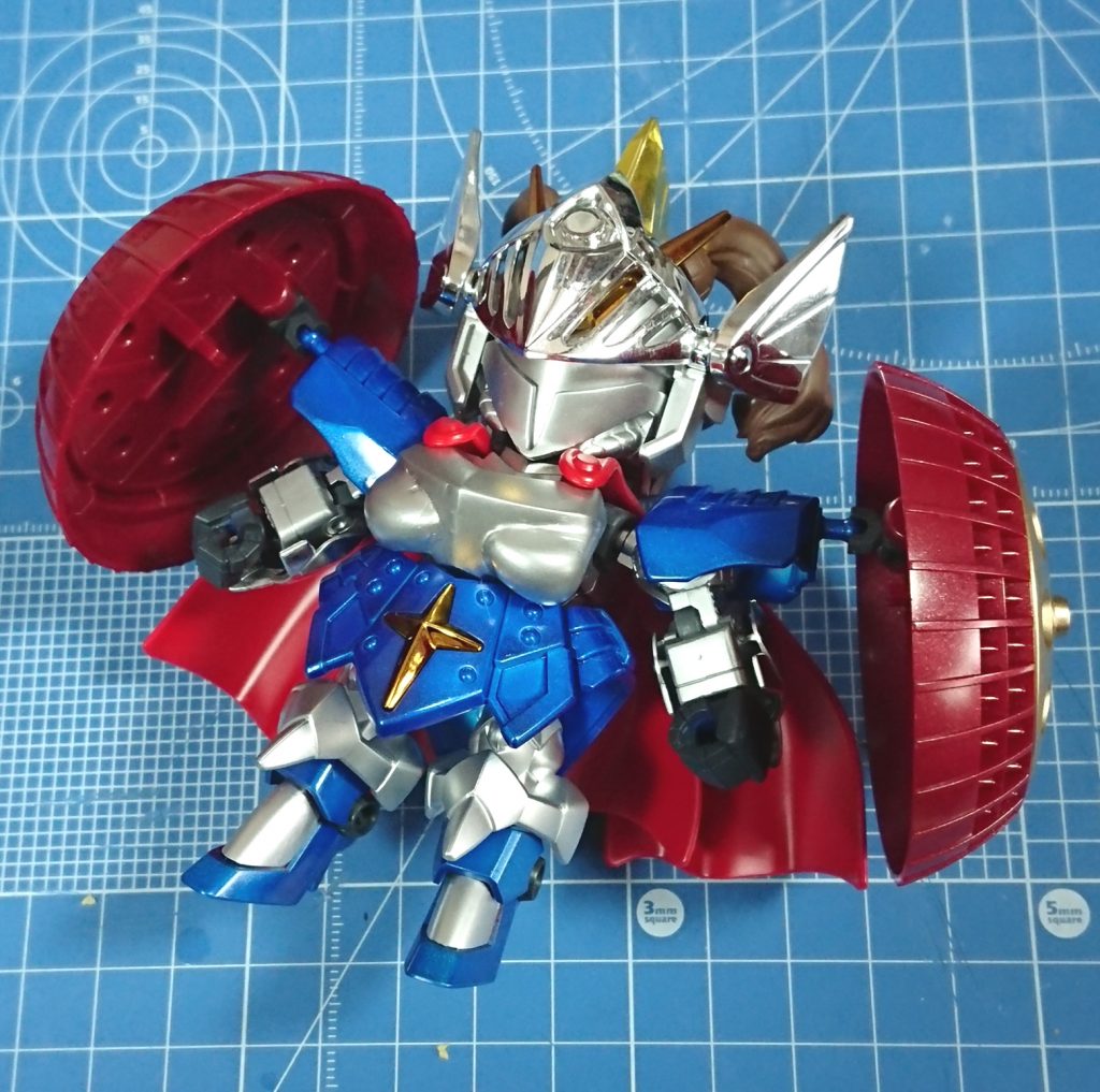 スプレー塗装を済ませた状態。
使用色はタミヤカラーのマイカブルー・シルバーリーフ・ゴールド・レッドブラウン、Mrカラーのジャーマングレー・メタリックレッド。
トサカ部分は銀メッキの上からクリアーイエローを吹いています。マントは成型色のまま。
最終的には部分塗装とプレミアムトップコートの半光沢で仕上げ。
モチベを切らさないための突貫制作ということもあって粗も多いですが、ほぼ全塗装レベルの作業をした初の作品ということでいい経験になったと思います。