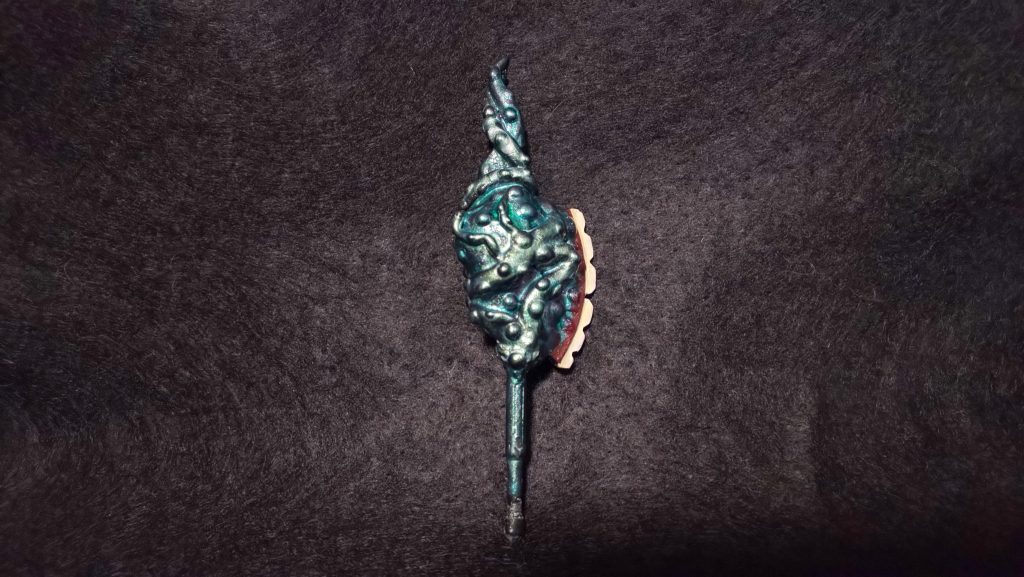 名状しがたいヒートホークのようなもの。塗装はカメレオンカラーという偏光塗料を塗っているので、角度で微妙に色が変わります。目をイメージしたクリアの部分は、市販のバーニアノズルパーツにクリアレジンを流したものを付けています。