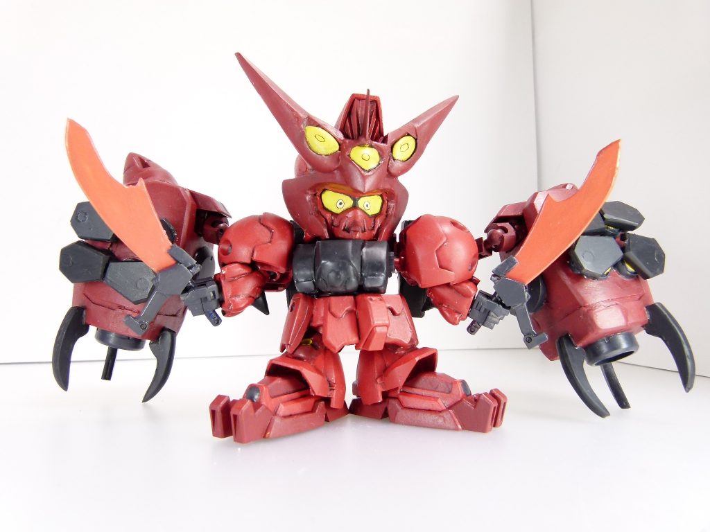 出力系統：ベース機は核融合駆動であるが、本機はそれに加えて太陽炉を追加で組み込んでおり、GN粒子を活かした重量の低減や空中戦、特殊トランザムが可能となる。オーガブレイド：本機の主武装、二本の実体剣。GN粒子をまとわせているのかどうかは不明。「オーガ」というダイバーを象徴する二本の剣はあらゆる獲物を引き裂く。頭部は孫策のものをベースに、上部をBB戦士のGP02から流用（孫策は造形を他のGPシリーズに寄せている部分もあるのでマスク部はエポパテで作成）。目は「この顔」しかないと思いました。角はプラ板で土台を作ってほぼ全てパテです。角の「眉」部分はHGダブルオーから。もうちょっと耳が伸びている気もしましたが、各部が大型化しているのとSDなので孫策ベースです。ブレイドは基部を劉備から、一部をIBAアサルトナイフから流用した以外プラ板でのスクラッチ。