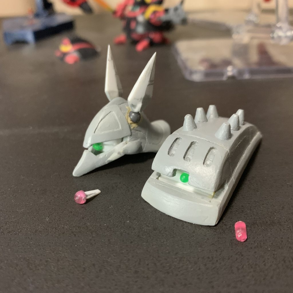 ランナーから切り離し、裏にプラのこで0.5mmの溝を付けて、0.5mmのプラ板を接着。モノアイレールにも0.5mmのスリットがあり、ここに挟むことによりモノアイを左右に動かせるようにしています。シールドのモノアイは動きません。アンテナの付け根には関節技の球体関節(4mm球)を使っていて、フレキシブルに動くようになっています。ただし、球体部分の塗装剥げに注意…😅