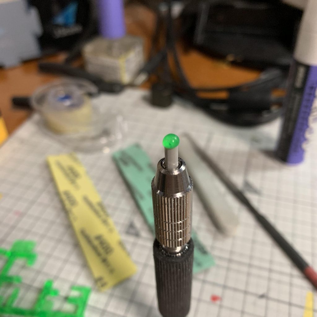 モノアイの製作。適当なランナーの先に瞬着でクリアパーツのランナーの一部をくっつけて、ピンバイスで回しながら磨きました。