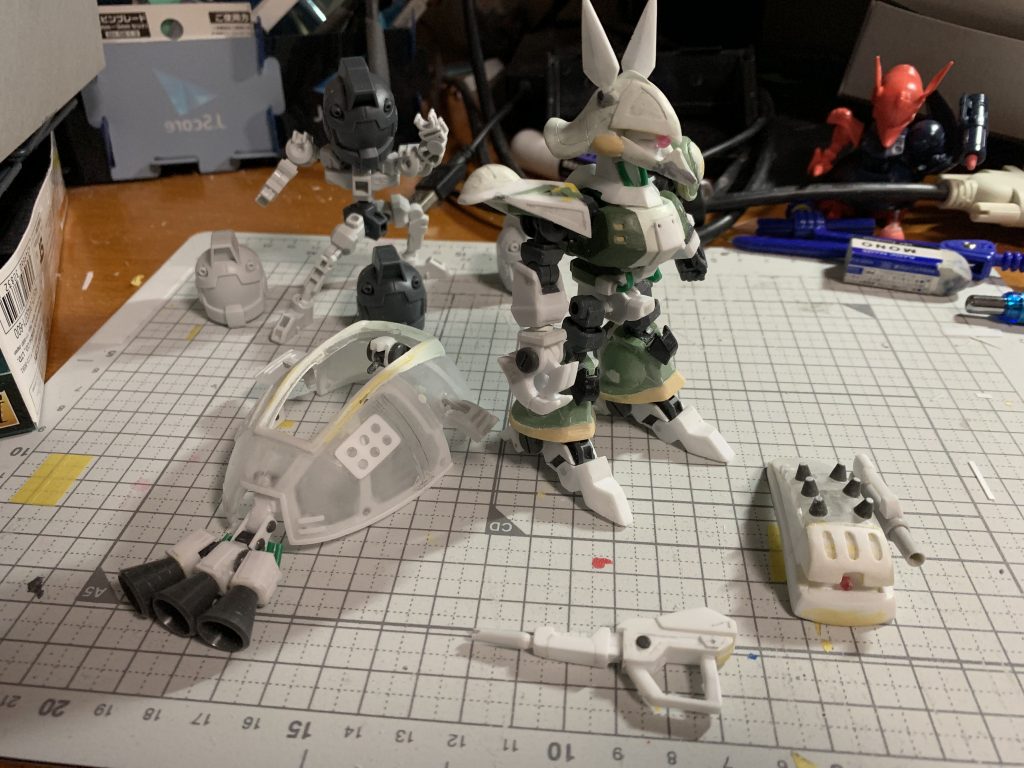 塗装前の状態。この写真なら緑色のザクのパーツが使われていることが分かる。甲羅状のスカートアーマーは東急ハンズに売っている[タマゴ型のディスプレイケース](https://hands.net/goods/4571253481411/)を使って作りました。うっかりこの素材を見つけたりしなければこんな無謀な挑戦はしなかった。ザクのパーツを使っているのは以下の箇所・胸部（パテ等で形状変更）・背中（そのまま）・バックパック（小型化した上でディテールアップパーツを追加）・スネアーマー（パテで裾延長）・両肩（フレームとの接続部分にザクの両肩。加えてシールドとスパイクアーマーも造形に使用）・両足首（フレームとの接続部分）それ以外の箇所はスクラッチです。コトブキヤ、Waveのディテールアップパーツ、ホビーベース関節技の球体関節、ポリパテ、プラ板プラ棒、ランナー、真鍮線などを使用。緑色のパイプは被膜付きの針金から芯の針金を抜いたものです。色もそのまま。フレームの加工は以下の箇所のみとなっています。・腰を縦に2mm延長・両膝を逆関節方向に曲がるように一部切除・首: 3mm軸とボールの間にスクラッチの首を追加変形はできませんがSDフレームも適用可能です。