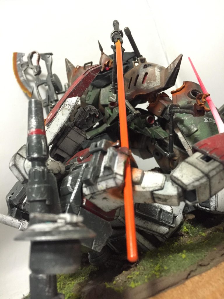 この写真だとわかりやすいんですが実はギャンの左腕はジムのビームキャノンをシールドごと受けて今にも引き千切れそうになってます。
流れ的にはジムがビームキャノンを撃ってギャンの左腕に当てたは良いものの、接近戦に持ち込まれて隠し腕を使ったヒートサーベルを食らって倒れこむ→そのままザクマシンガンを改造したヒートホークでとどめを刺そうとするもシールドで何度か受け止められる→そうこうしてるうちにジム側もこんなところで死んでたまるかとビームサーベルを抜刀→ギャン側はそれをさすまいと隠し腕でビームサーベルを受け止めて時間稼ぎに→さぁ!生き延びるのはどちらだ!って感じです。