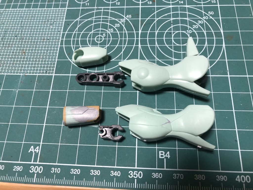 足回り関節の比較。
上が素組みのパーツで下が加工後。
大腿部の上下3分の1ずつを切り落としてプラ板で組んで、2mmプラ棒を通して整形。
そのプラ棒に噛ませるためにポリキャップを半分ほど切り落として丸い部分をCの字に切り欠いて取り付けできるように加工。