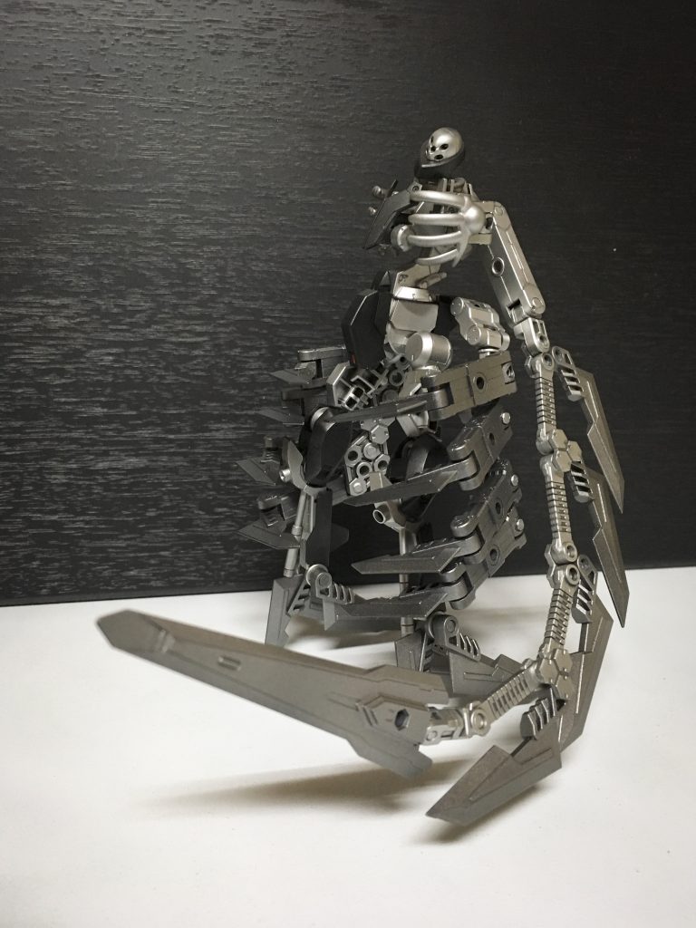 エピーヌ・ドルサル
両腕を失った本機の背中から伸びる多関節の奇剣
くねるように動くその様は鞭に似ている