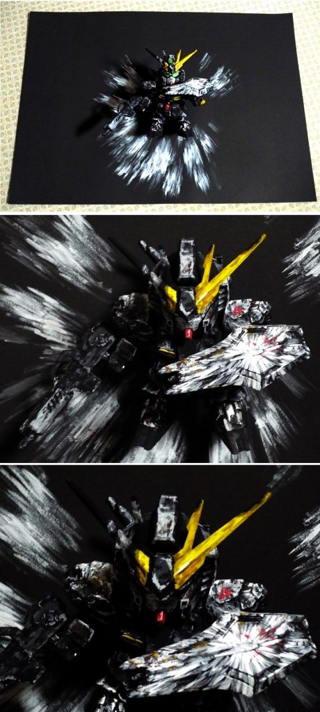 νガンダムと背景黒紙を室内の明かりの下に普通に置くとこんなカンジです。
アンテナ部分はイラストだと片側が折れて無くなっていたり
残った先端部分も曲がったような表現になっているのですが
そこはキットの加工を行わず黒塗りして背景と同化させて
消えて見えない…感じにしてみました。
実は一番苦労した部分は右肩のダメージ表現です。難しかったです。
