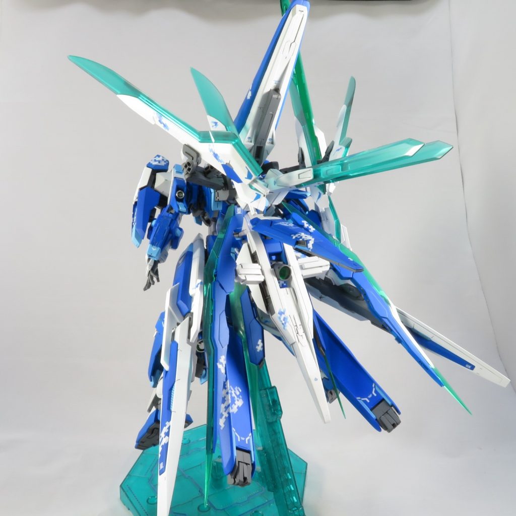 正面からのイメージは大きく崩さず、側面から後ろに回り込んだときに剣の集合体的なインパクトを
与えられるよう背後にソードビットを配置、中心からパッと四方に広がるデザインに。
使用パーツはクアンタのシールドとGNアームズ（HG）から流用、デザイナーが同じだからか
特にディテールをいじらなくても馴染みました。